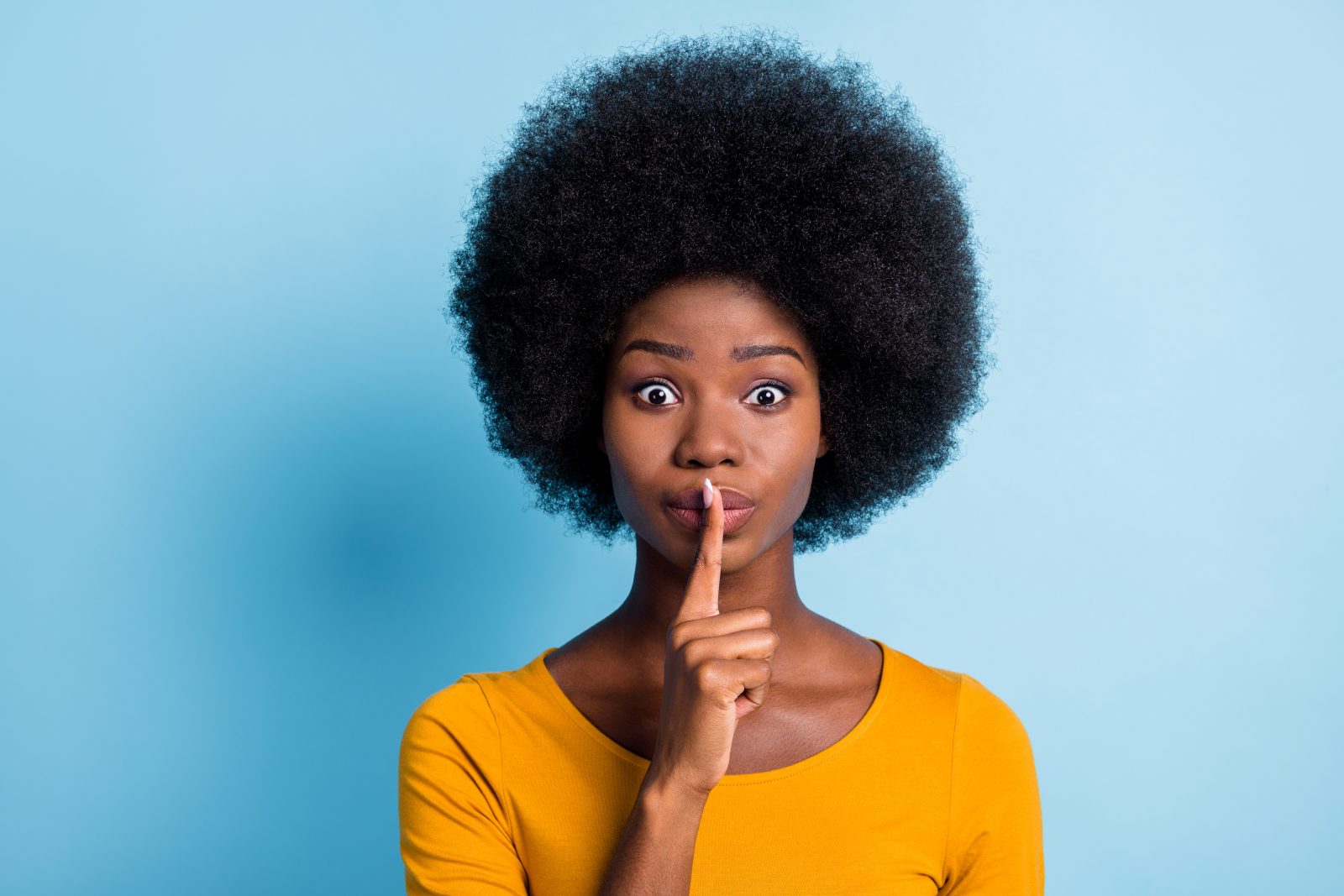 Photo portrait of black skinned girl keeping finger near lips speechless quietly isolated on vibrant blue color background.