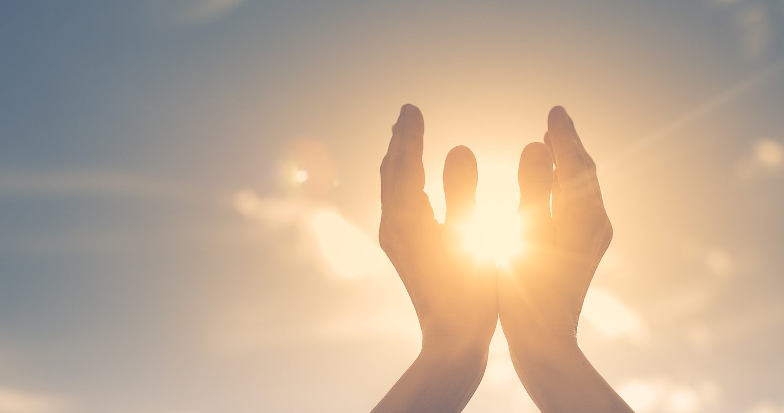 Woman hands holding the sun at dawn. Freedom and spirituality co